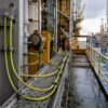 Green-yellow offshore earthing and bonding cables installed on an oil and gas platform