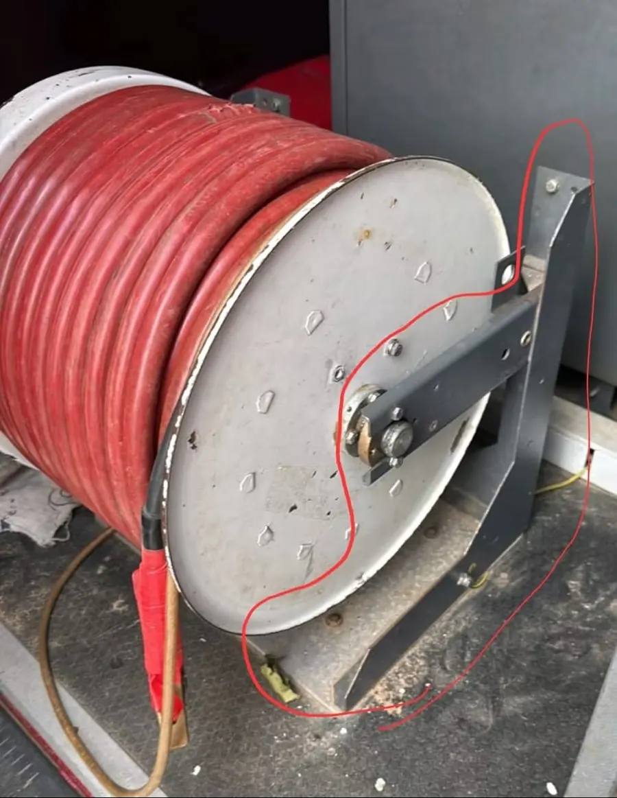 Red high voltage test cable wound on a steel reel, with the drum barrel highlighted by the customer