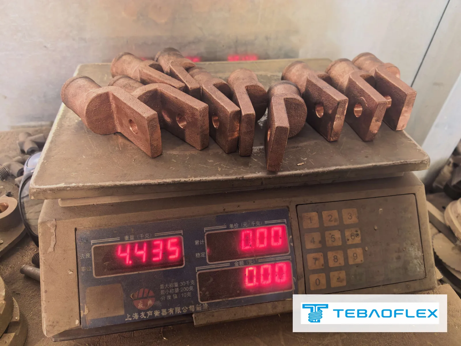 Sembilan lug tembaga tuang 1100/24 yang dimesin di atas penimbang meja yang menunjukkan 4.435 kg