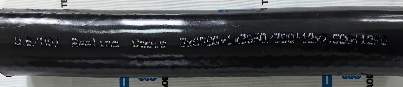 Marquage sur la gaine d'un câble noir pour tambour 0.6/1 kV portant l'inscription "0.6/1KV Reeling Cable 3x95SQ+1x3G50/3SQ+12x2.5SQ+12FO"