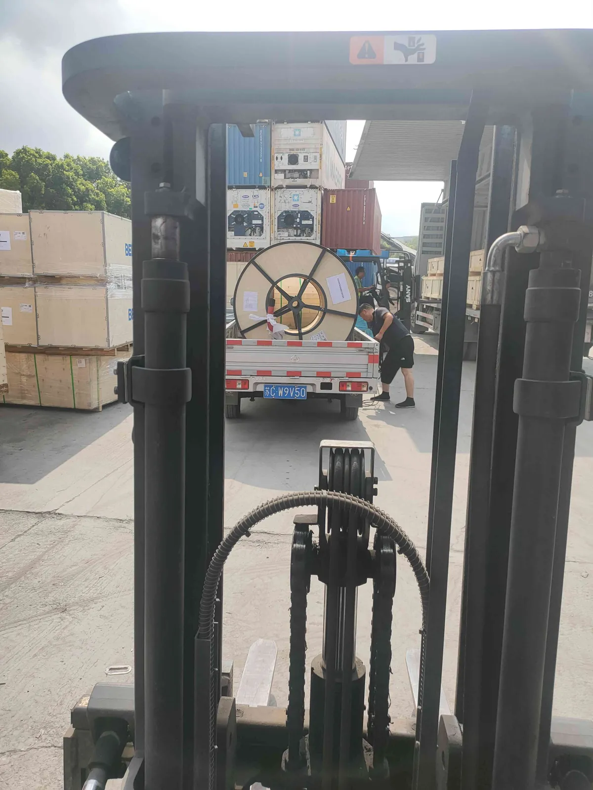 Forklift loading a reeling cable drum for shipment to Vietnam