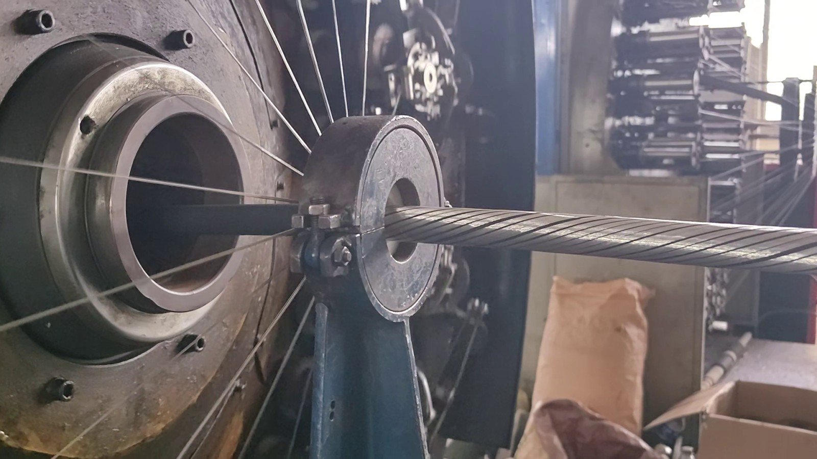 Serving head on the cable line with tinned copper wires converging from the rotating head onto the core at the die