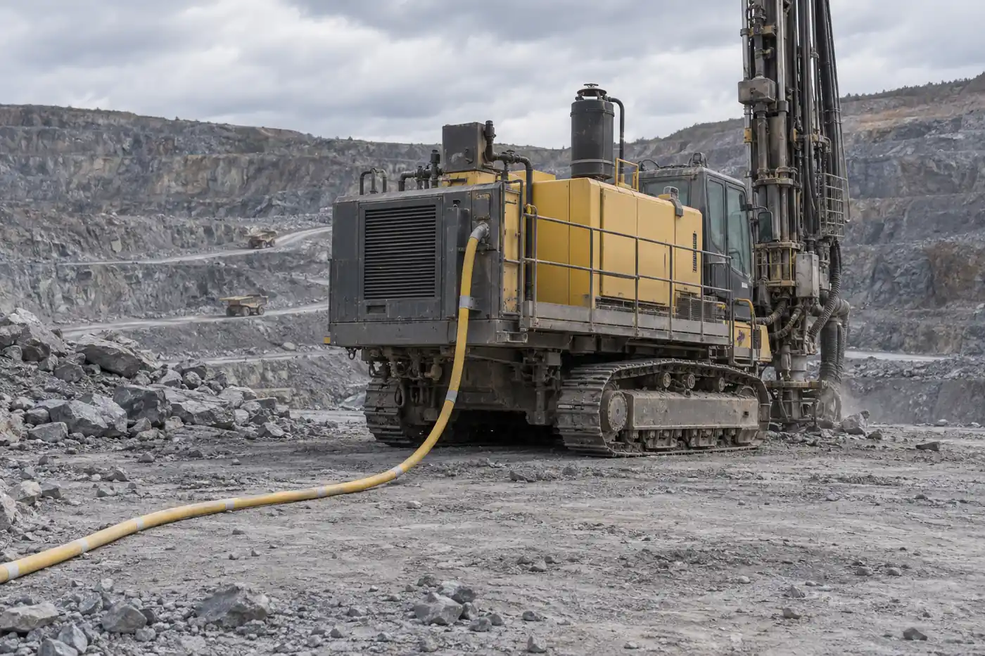 Yellow heavy-duty trailing cable supplying a mobile drill rig in an open-pit mine