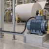 Black screened VFD motor cable linking a paper-processing motor and a closed drive cabinet