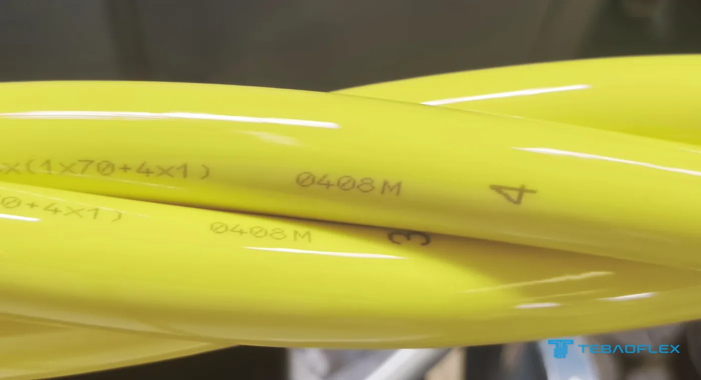 Close-up of the twisted cores: sheath print 4×(1×70+4×1) with metre marking 0408M and the core numbers 3 and 4 printed on the yellow PUR sheaths