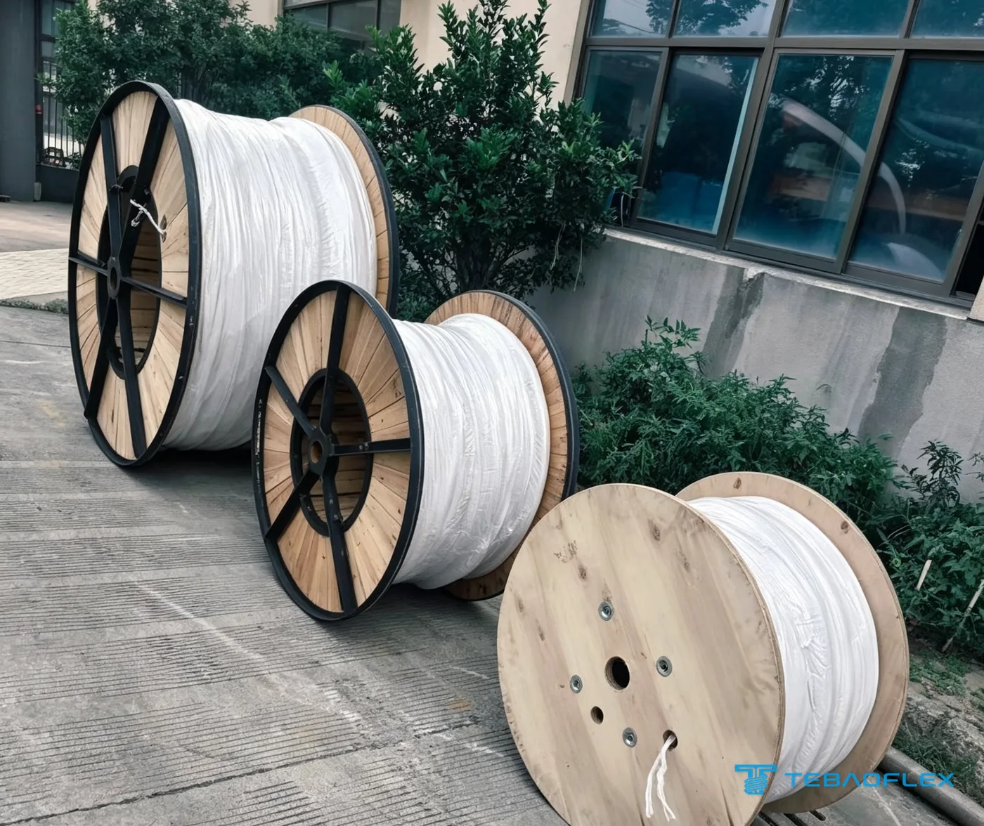 Cable drums wrapped in protective film outside the TEBAOFLEX factory before lagging