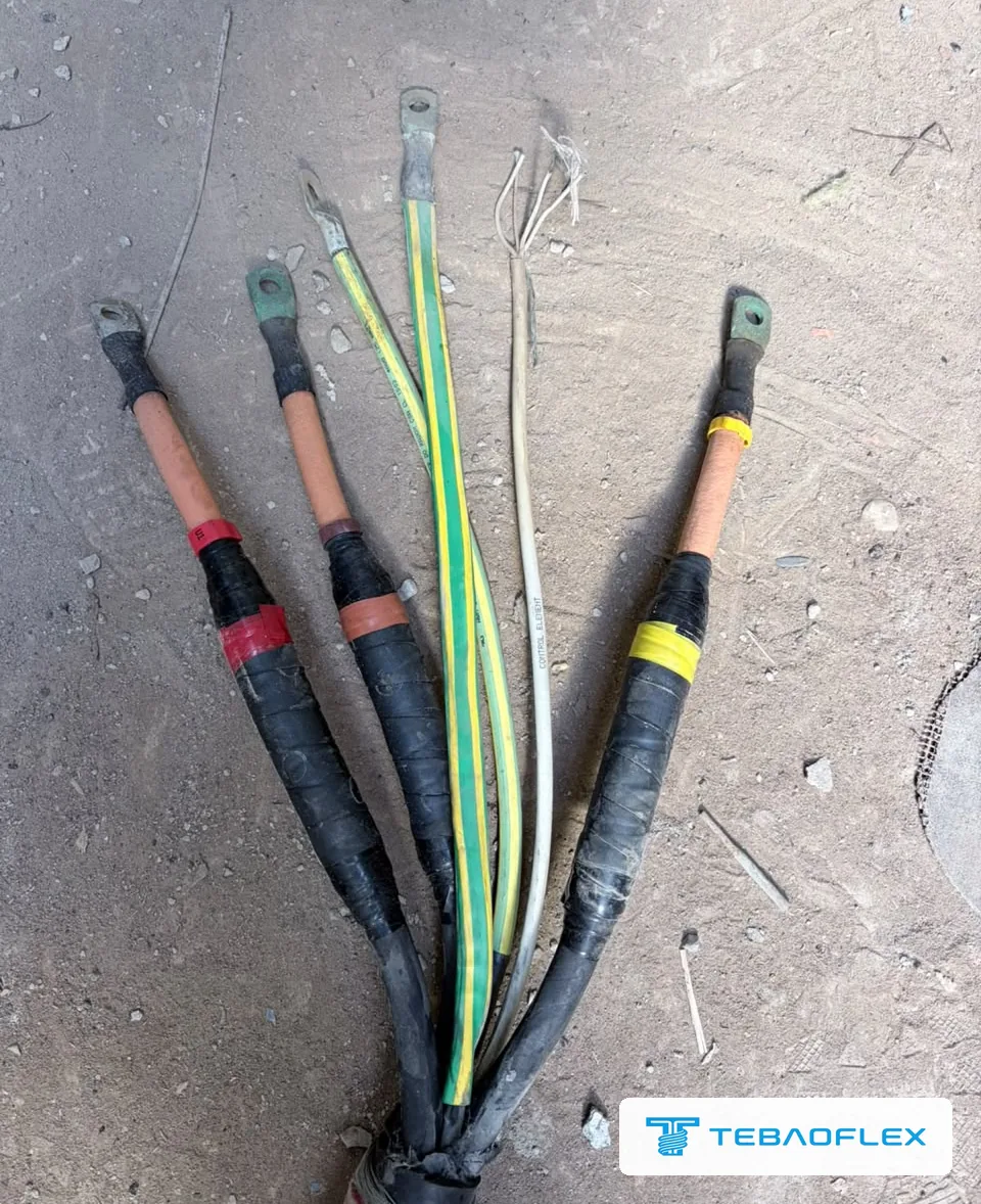 Terminated cores of the existing pump cable laid out: three power cores, two green-yellow earth conductors and the white control element
