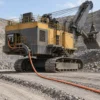 (N)TMCGEH3S electric mining shovel application Orange mining trailing cable routed from the rear of an electric rope shovel in an open-pit mine