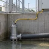 S07BQ-F submersible pump cable application Yellow S07BQ-F power cable routed to a submersible pump with a separate lifting chain