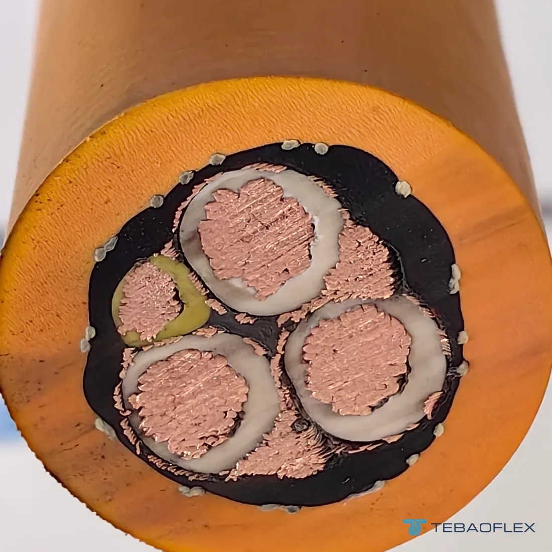 Coupe transversale du câble SHD-GC 2 kV 3×6+2×10+1×10 AWG : trois conducteurs de puissance en cuivre à isolation EPR, chacun enveloppé d'un blindage tressé en cuivre étamé, deux conducteurs de mise à la terre nus en cuivre étamé, un conducteur de contrôle de terre jaune, une tresse de renfort et la gaine en TPU orange