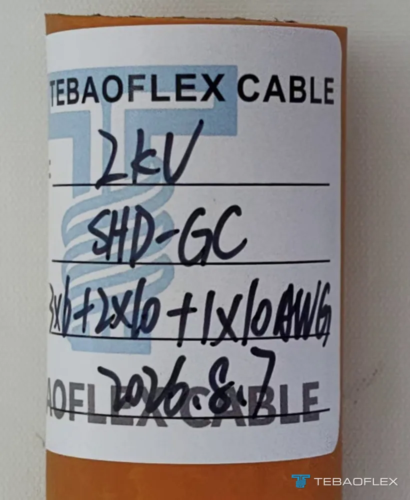 Échantillon coupé du câble orange avec une étiquette TEBAOFLEX CABLE manuscrite : 2KV, SHD-GC, 3x6+2x10+1x10AWG, 2026.8.7