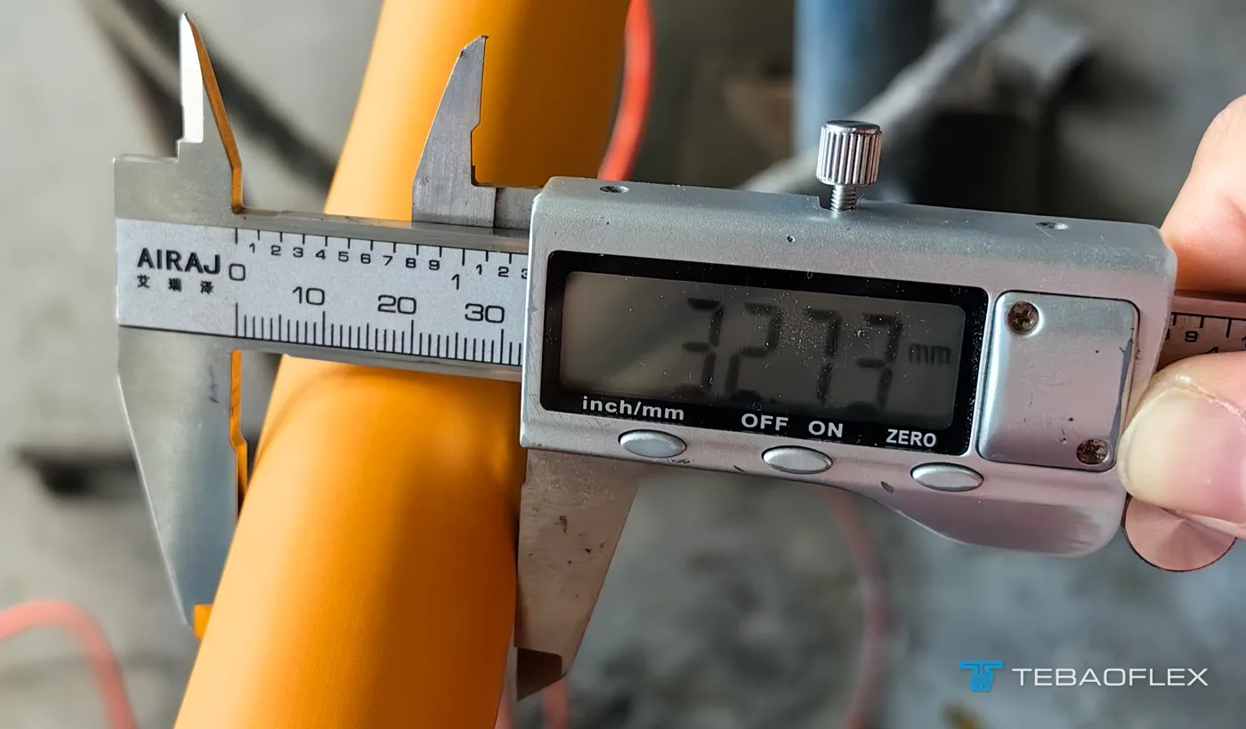 Pied à coulisse numérique sur le câble orange indiquant 32.73 mm
