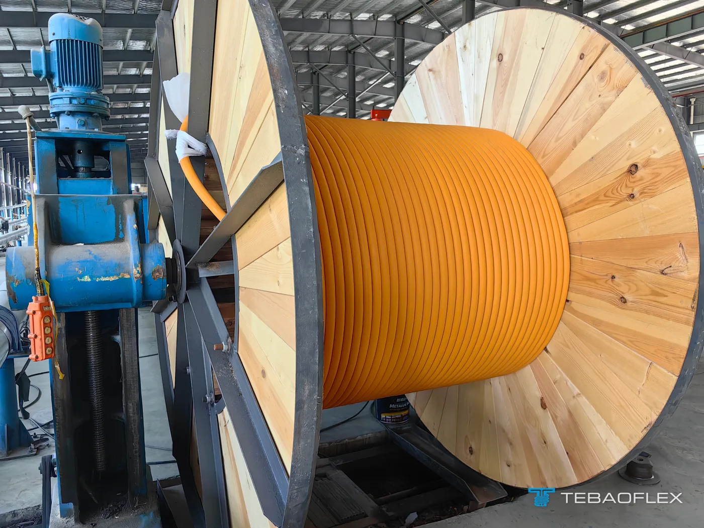 Le câble SHD-GC orange enroulé sur un touret en bois à flasques en acier, sur le poste d'enroulement à l'usine