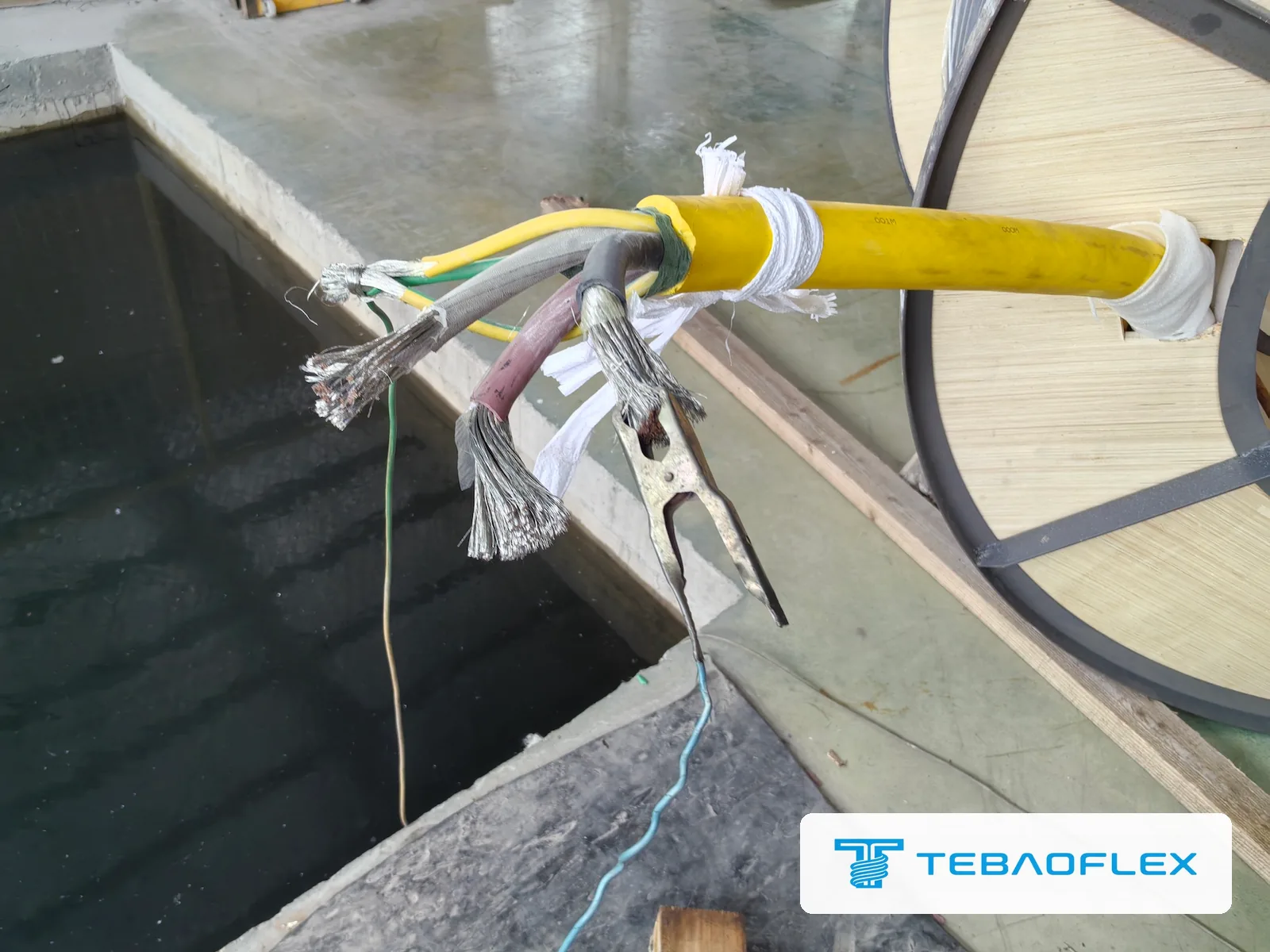 Test leads clipped to the stripped cores of the finished 3×185 cable for the voltage test
